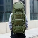 Adult male wearing extra-large army green hunter backpack with MOLLE webbing on a mountain trail